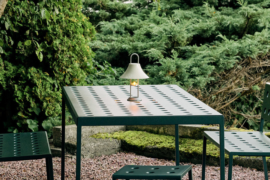 HAY portable design lamp buiten op een groene tafel