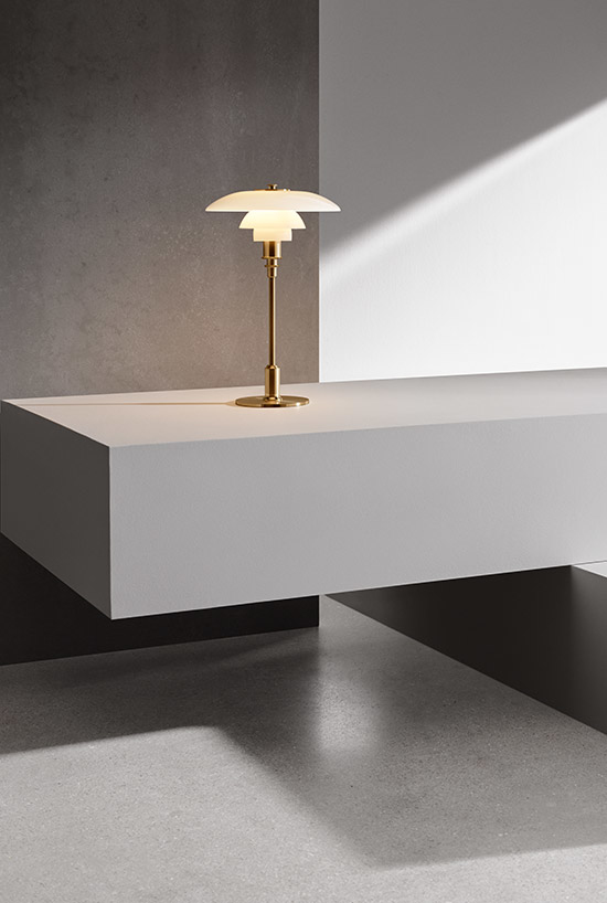 PH3 design tafel lamp van Louis Poulsen op een betonnen bank
