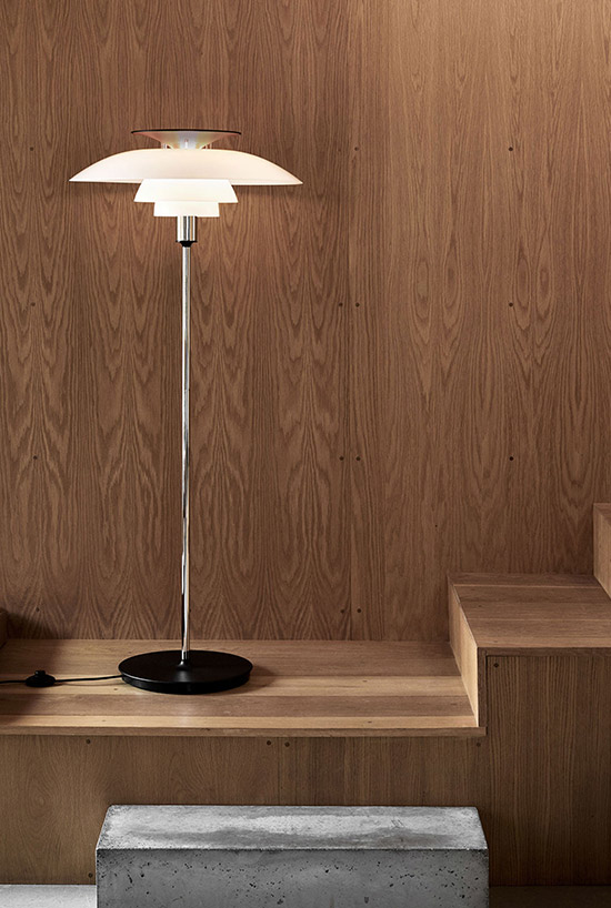 Design vloerlamp van Louis Poulsen met een houten achtergrond